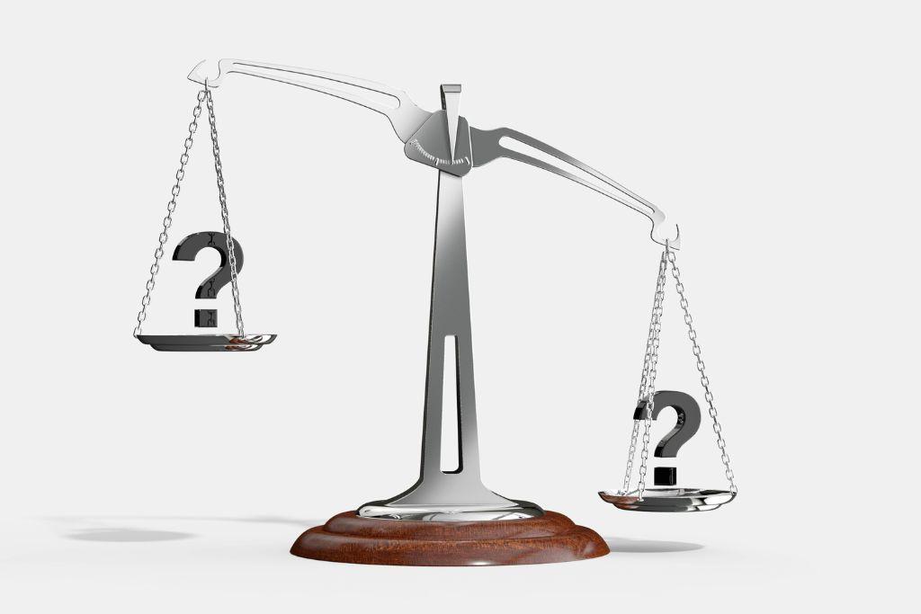 Scale comparing two factors. A question mark is shown on both sides of the scale.