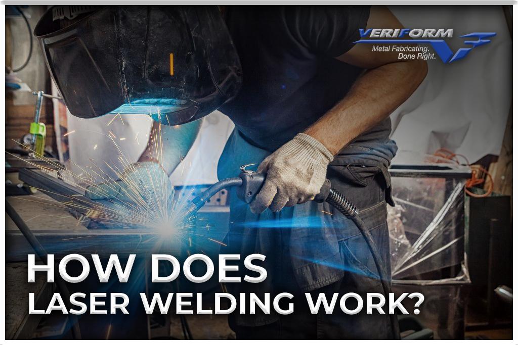 Young man in protective suit preforming laser welding using a laser welder.