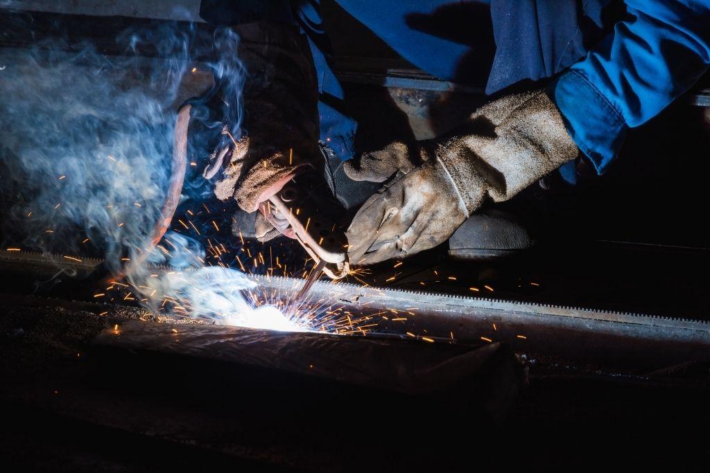 Using a stick welder to perform SMAW.